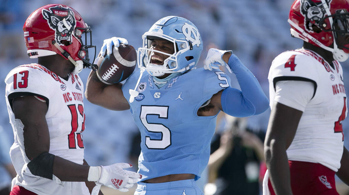 North Carolina’s Dazz Newsome (5) celebrates in front of N.C. State’s Tyler Baker-Williams (13) after a nine-yard gain in the third quarter at Kenan Stadium on Saturday, October 24, 2020 in Chapel Hill, N.C.