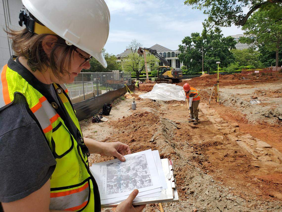 Mary Beth Fitts, assistant state archaeologist,&nbsp;works on the NC Freedom Park site on April 29, 2022 in downtown Raleigh. Archaeologists have revealed a stone foundation wall of a circa 1850 house on the land that is being transformed into a park celebrating the Black experience in the state. In the background is the Legislative Building on Wilmington Street. The park entrance will be on Wilmington Street.