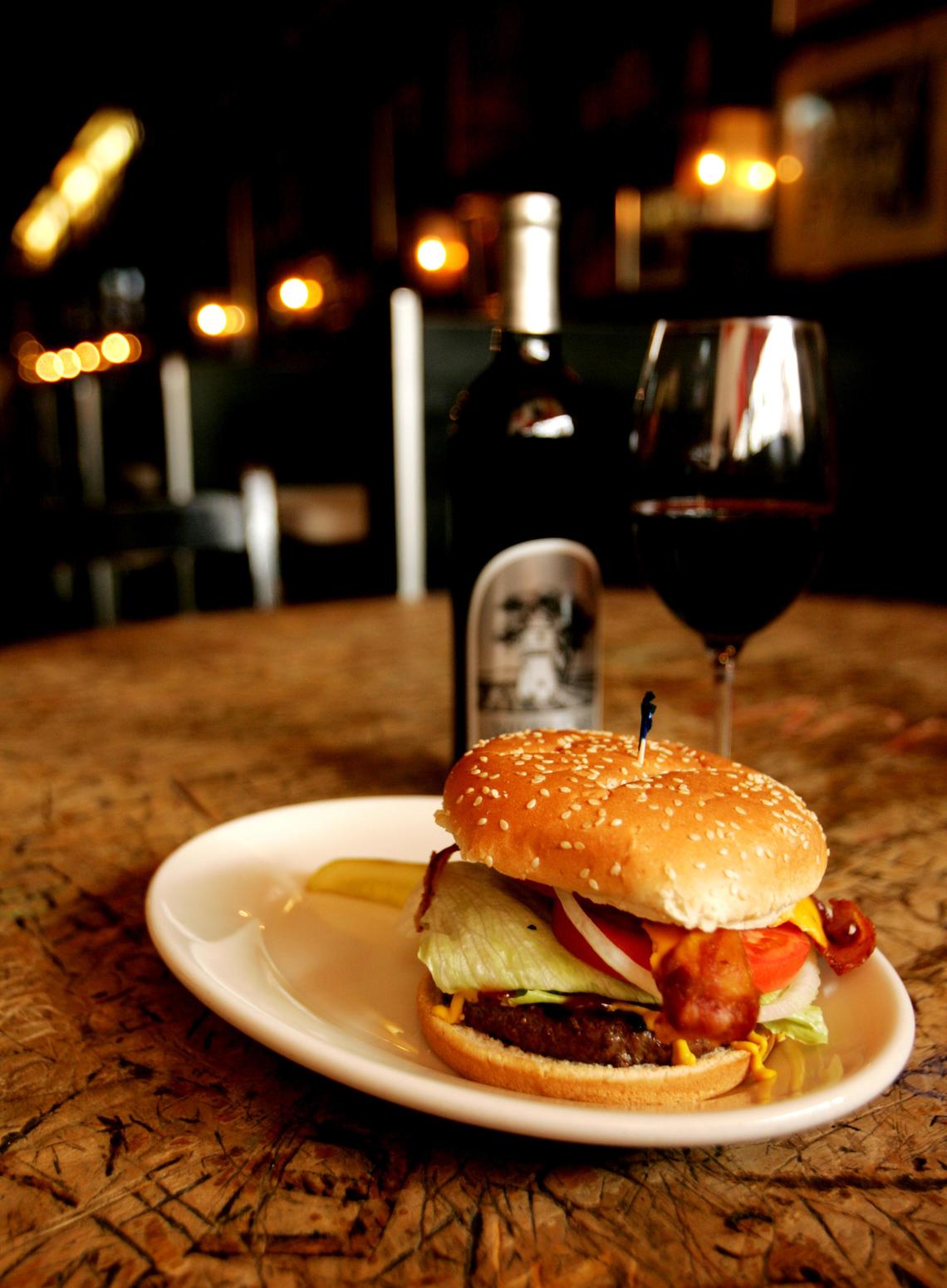 A burger “all the way” from The Players Retreat in Raleigh is served with a 2003 Silver Oak Cabernet Sauvignon.