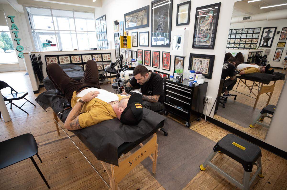 Tattoo artist Matt Evans gives Ben Coffman some new ink at Welcome Tattoo in Durham, N.C. on Wednesday, June 21, 2023.
