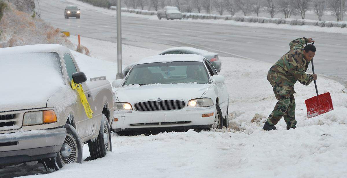 Good samaritan Ken Barkley helps Brandon Mayfield, of Durham, NC retrieve his car on the Avondale Road exit off of southbound I-85 Thursday Feb. 13, 2014. Mayfield had to abandon his car, along with hundreds of other drivers, yesterday afternoon during the height of the storm.