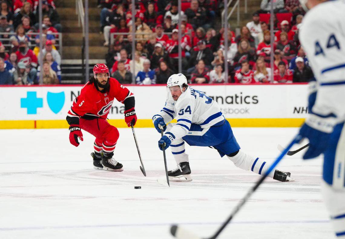 Toronto Maple Leafs center Auston Matthews (34) skates with the puck against Carolina Hurricanes defenseman Jalen Chatfield (5) during the first period at Lenovo Center.