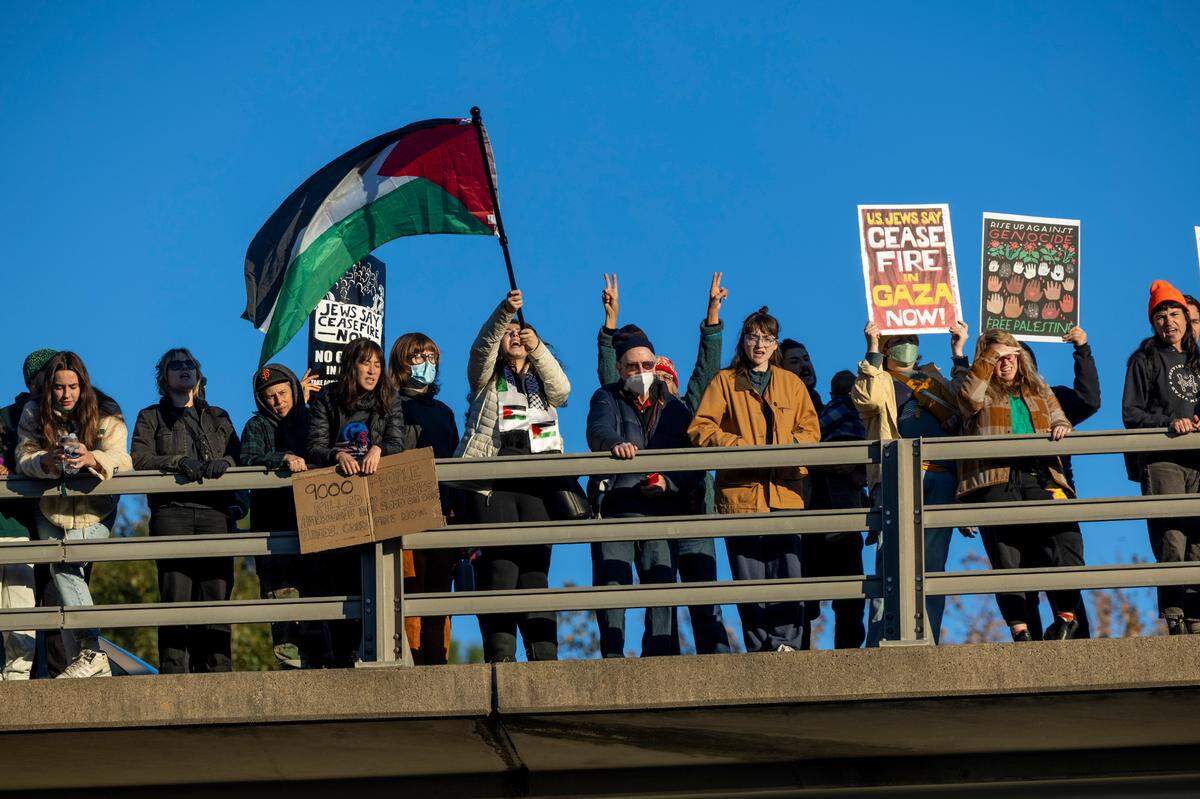 Protesters demonstrate from the Mangumn Street bridge over the Durham Freeway as some protesters block the northbound lanes of freeway for hours Thursday evening, Nov. 2, 2023 while demanding a ceasefire in the Israel-Gaza War as police warned of arrests.