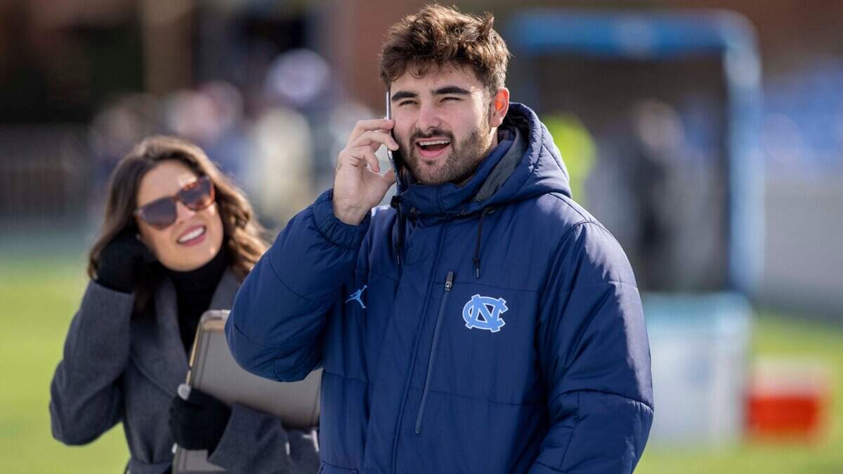 North Carolina quarterback Sam Howell, dressed in street clothes, takes a call on his phone an hour before the Tar Heels’ game against Wofford on Saturday, November 20, 2021 at Kenan Stadium in Chapel Hill, N.C.