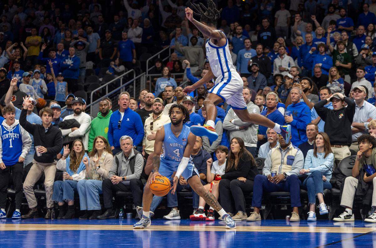 North Carolina’s R.J. Davis (4) fakes Kentucky’s Rob Dillingham (0) as he lines up a three point shot in the second half on Saturday, December 16, 2023 at State Farm Arena in Atlanta, Georgia.