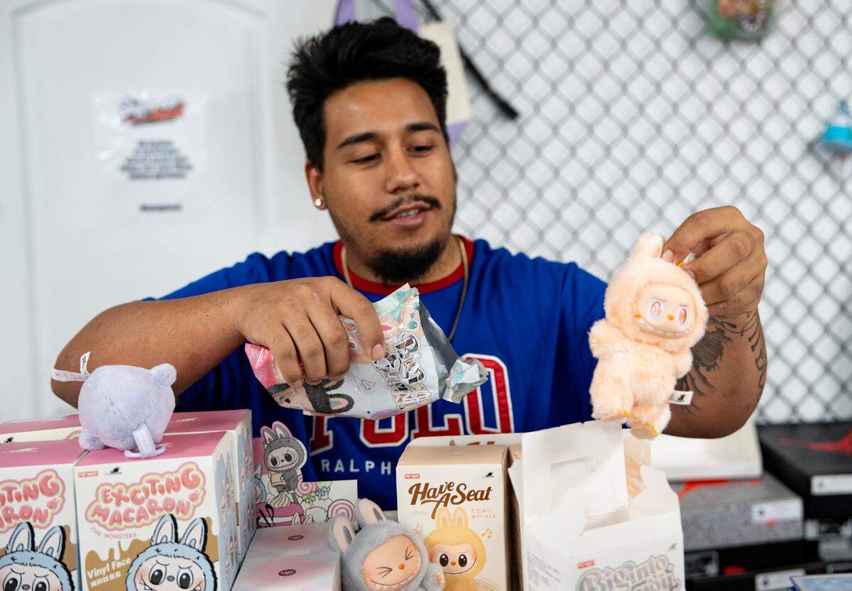 Selvia Herrera, owner of Superior Heat in Raleigh, N.C. unboxes Labubu toys on Friday, July 11, 2025.