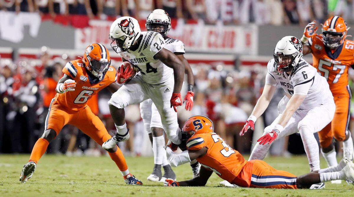 N.C. State running back Bam Knight (24) looks to escape Syracuse defensive back Eric Coley (34) during the first half of N.C. State’s game against Syracuse at Carter-Finley Stadium in Raleigh, N.C., Thursday, Oct. 10, 2019.