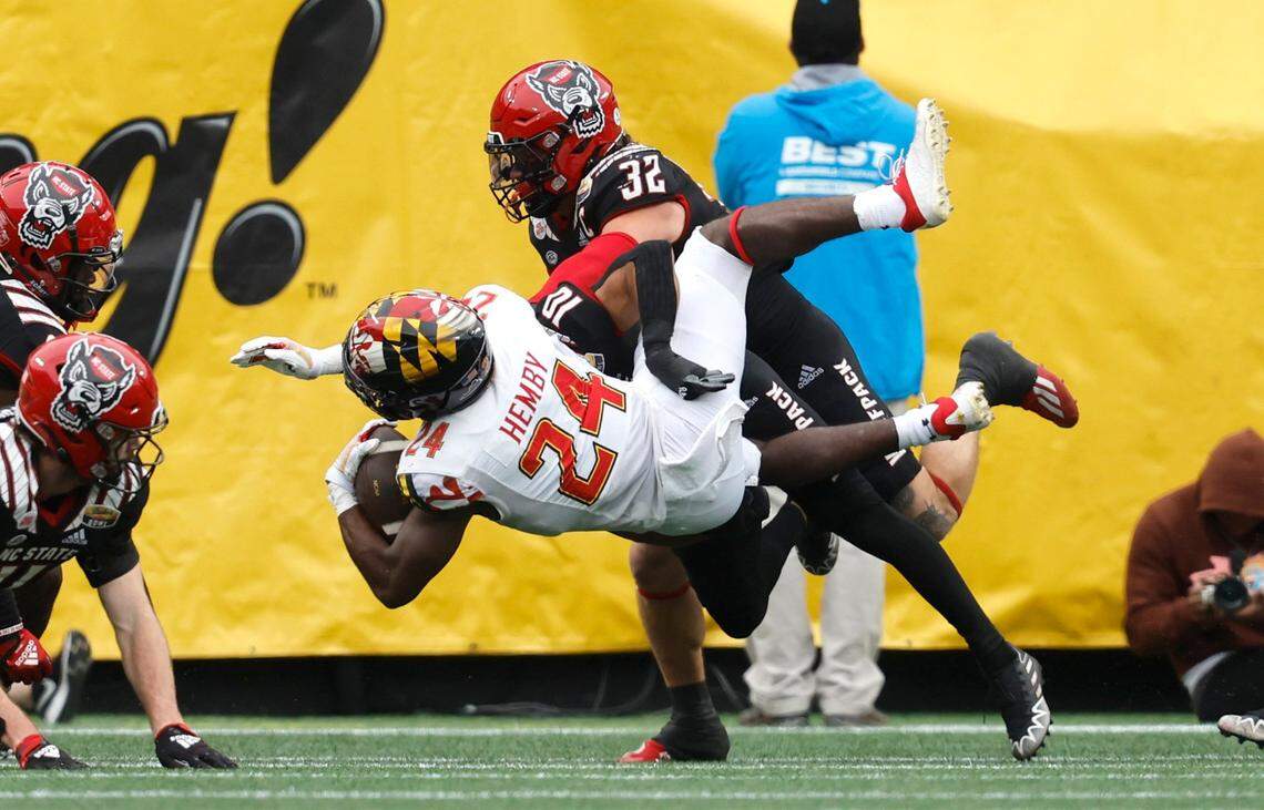 N.C. State’s Tanner Ingle (10) and Drake Thomas (32) tackle Maryland running back Roman Hemby (24) during the first half of N.C. State’s game against Maryland in the Duke’s Mayo Bowl at Bank of America Stadium in Charlotte, N.C., Friday, Dec. 30, 2022.