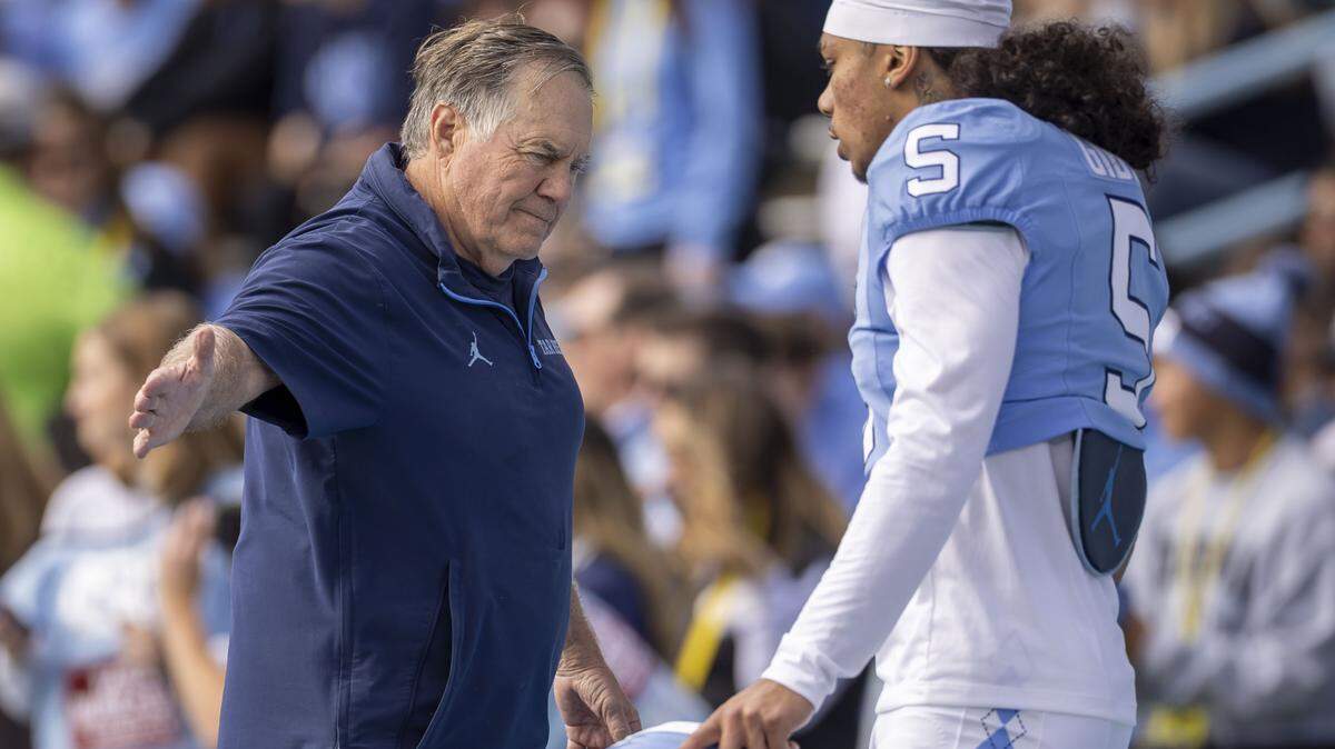 North Carolina coach Bill Belichick greets defensive back Gavin Gibson (5) during the pre-game warm up prior to the Tar Heels’ game against Virginia on Saturday, October 25, 2025 at Kenan Stadium in Chapel Hill, N.C.