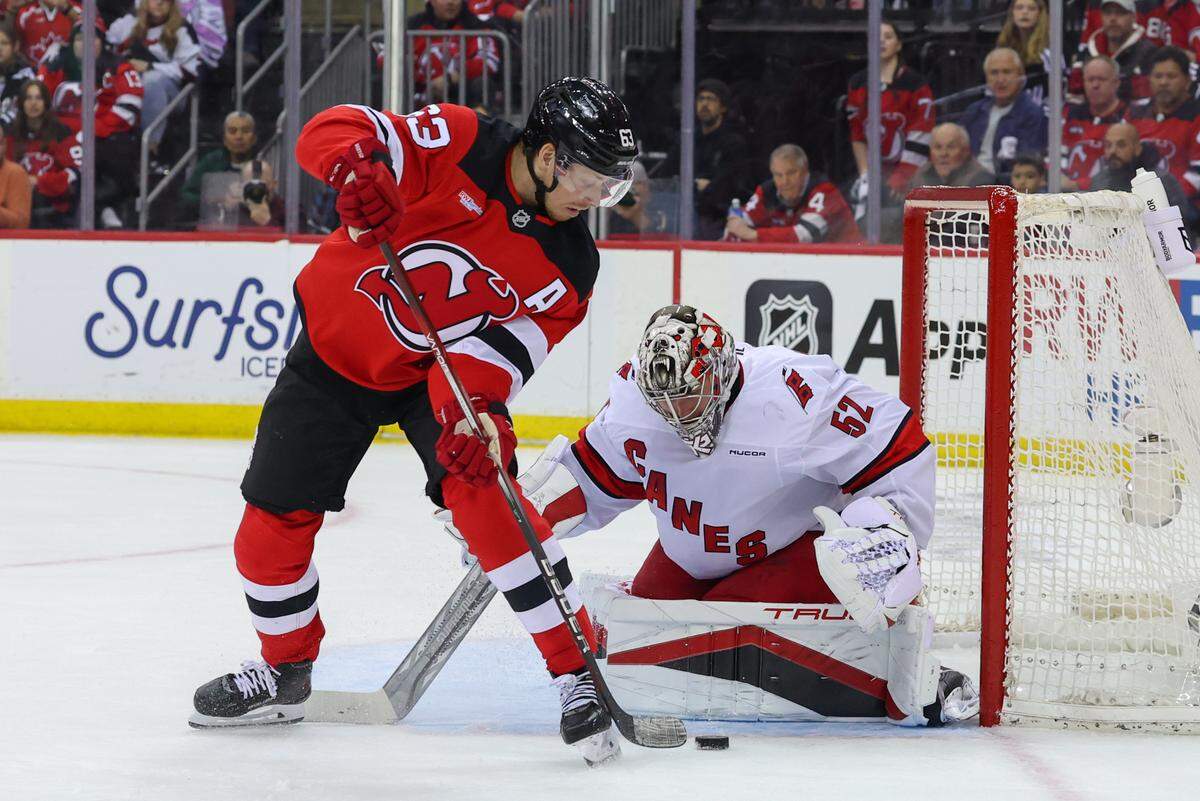 Apr 27, 2025; Newark, New Jersey, USA; Carolina Hurricanes goaltender Pyotr Kochetkov (52) makes a save against New Jersey Devils left wing Jesper Bratt (63) during the second period in game four of the first round of the 2025 Stanley Cup Playoffs at Prudential Center. Mandatory Credit: Ed Mulholland-Imagn Images