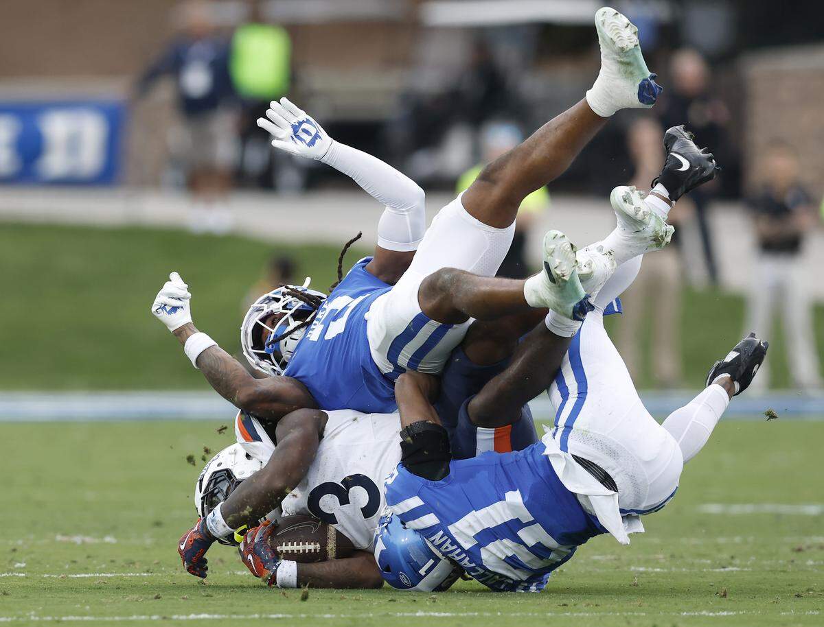 Duke’s Jaiden Francois and Landan Callahan tackle Virginia’s J'Mari Taylor during the first half of the Blue Devils’ game on Saturday, Nov. 15, 2025, at Wallace Wade Stadium in Durham, N.C. 