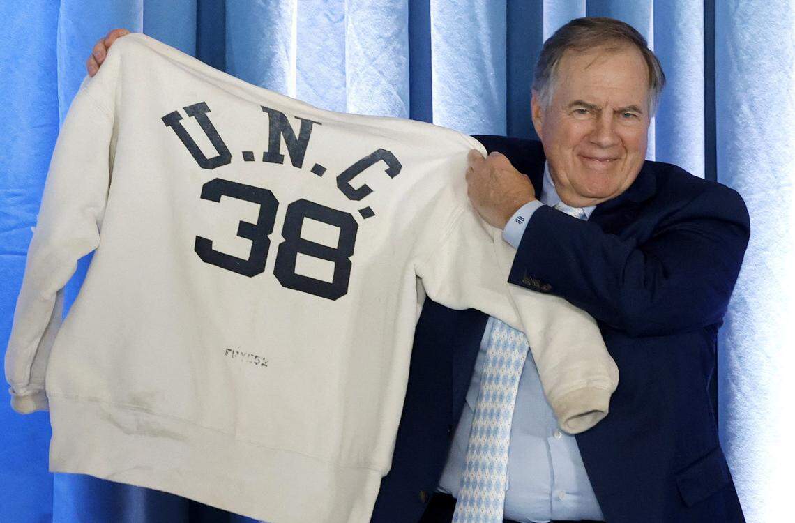 New North Carolina head football coach Bill Belichick holds up his father’s Carolina sweatshirt during a press conference announcing his hiring at the Loudermilk Center for Excellence at UNC in Chapel Hill, N.C., Thursday, Dec. 12, 2024.