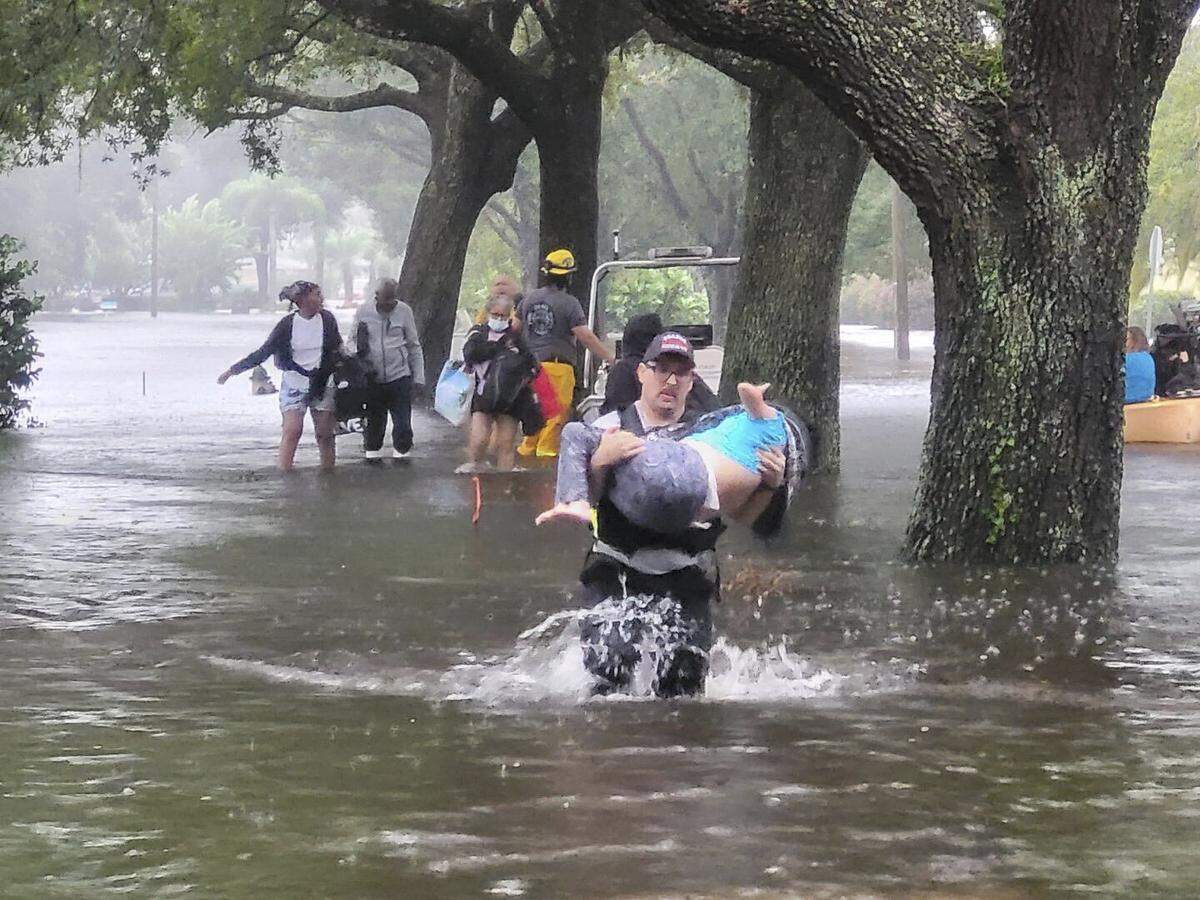 This photo provided by Orange County Fire Rescue’s Public Information Office, Orange County firefighters help people stranded by Hurricane Ian early Thursday, Sept. 29, 2022 in Orange County, Fla. Ian marched across central Florida on Thursday as a tropical storm after battering the state’s southwest coast, dropping heavy rains that caused flooding and led to inland rescues and evacuations. (Orange County Fire Rescue’s Public Information Office via A)