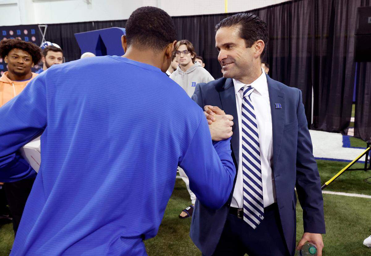 Manny Diaz greets wide receiver Jordan Moore after a press conference at Pascal Field House in Durham, N.C., where Diaz was introduced as Duke football’s new head coach Saturday, Dec. 9, 2023.
