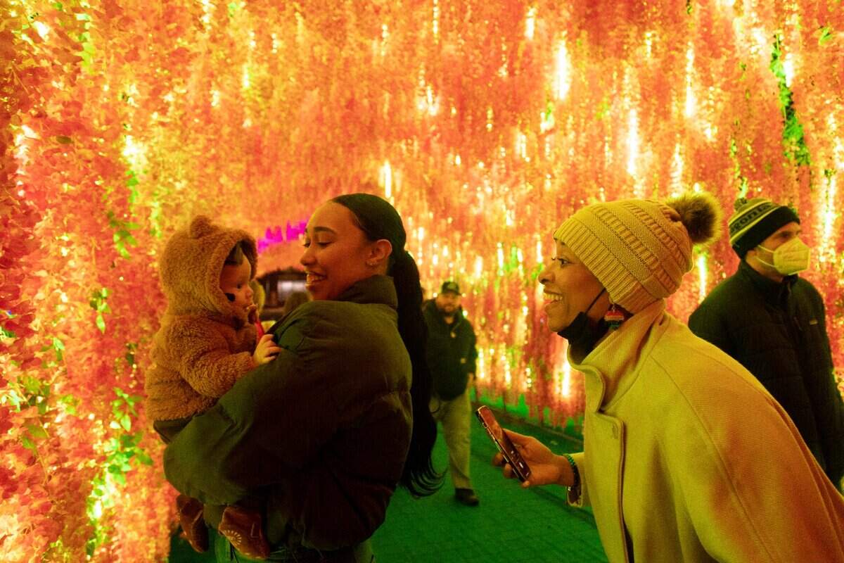 Deiara Frye, center, with her four-month-old, Samaiha Frye, and mom, Shamina Williams, visit the Chinese Lantern Festival for the first time at Koka Booth Amphitheatre in Cary on Wednesday evening, Dec. 22, 2021.