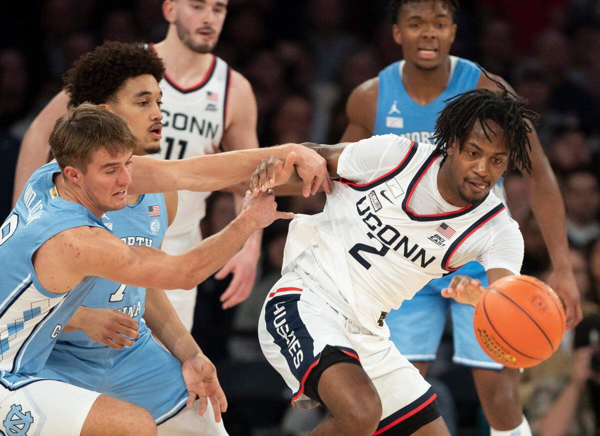North Carolina’s Paxson Wojcik (8) and Seth Trimble (7) try for a steal from Connecticut’s Tristen Newton (2) during the second half in the Jimmy V Classic on Tuesday, December 5, 2023 at Madison Square Garden in New York, NY.