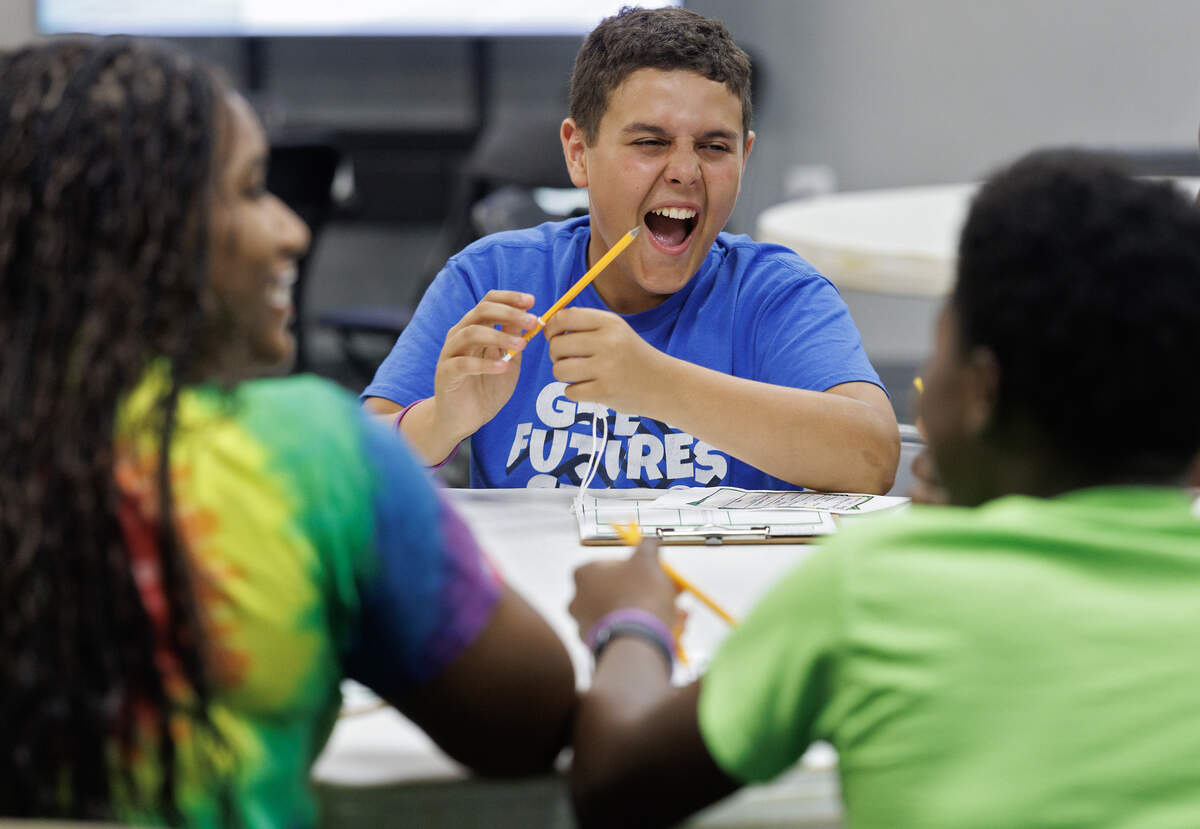 Dom C, center, shares a laugh with other teens before meeting with volunteers to come up with a financial plan.