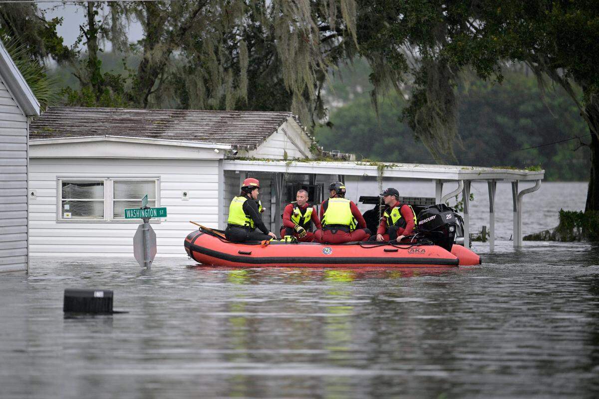 First responders with Orange County Fire Rescue check the welfare of residents as they make their way through a flooded neighborhood in the aftermath of Hurricane Ian, Thursday, Sept. 29, 2022, in Orlando, Fla.