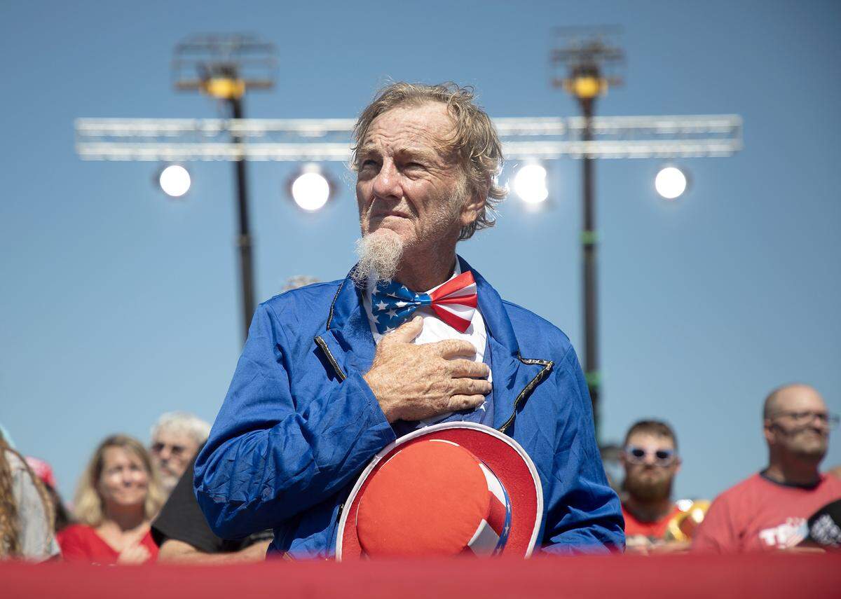 Supporters listen during the National Anthem at the start of a rally held by former President and current Republican candidate for president Donald Trump in Wilmington, N.C. on Saturday, Sept. 21, 2024.