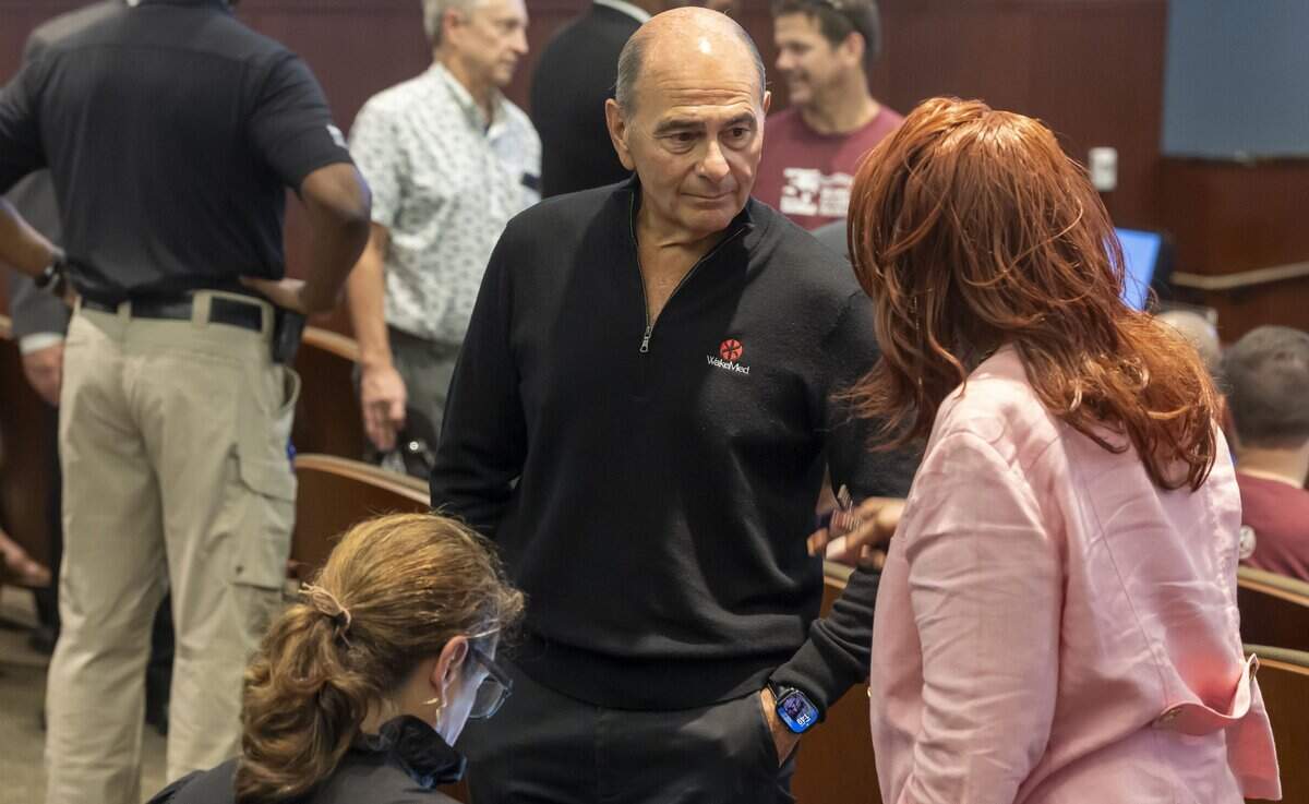 Donald Gintzig, CEO of WakeMed Health & Hospitals, talks with Octavia Rainey prior to the Wake County Commissioners meeting on Monday, July 6, 2026 in Raleigh, N.C.