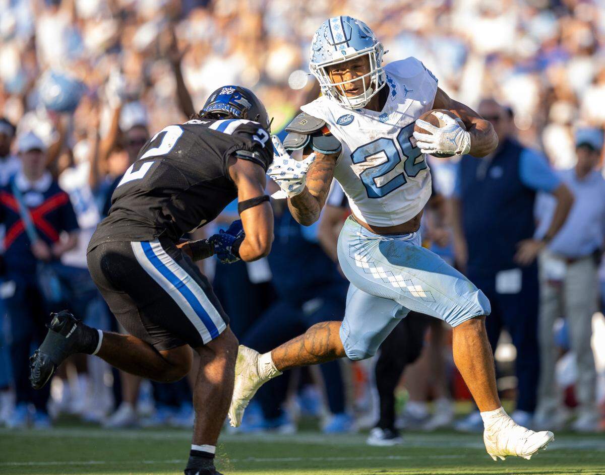 North Carolina running back Omarion Hampton (28) stiff arms Duke safety Jaylen Stinson (2) as he picks up 37-yards after a reception from quarterback Jacolby Criswell in the second quarter on Saturday, September 28, 2024 at Wallace Wade Stadium in Durham, N.C.