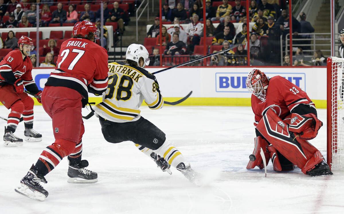 Carolina Hurricanes goalie Scott Darling (33) blocks while Justin Faulk (27) defends against Boston Bruins’ David Pastrnak (88), of the Czech Republic, during the first period of an NHL hockey game in Raleigh, N.C., Tuesday, Oct. 30, 2018.