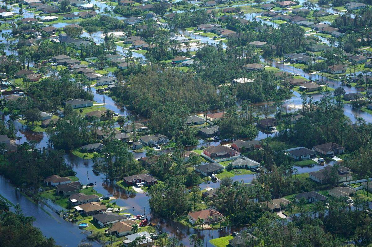 Homes are surrounded by flood waters caused by Hurricane Ian, Thursday, Sept. 29, 2022, in Fort Myers, Fla. Climate change added at least 10% more rain to Hurricane Ian, a study prepared immediately after the storm shows.