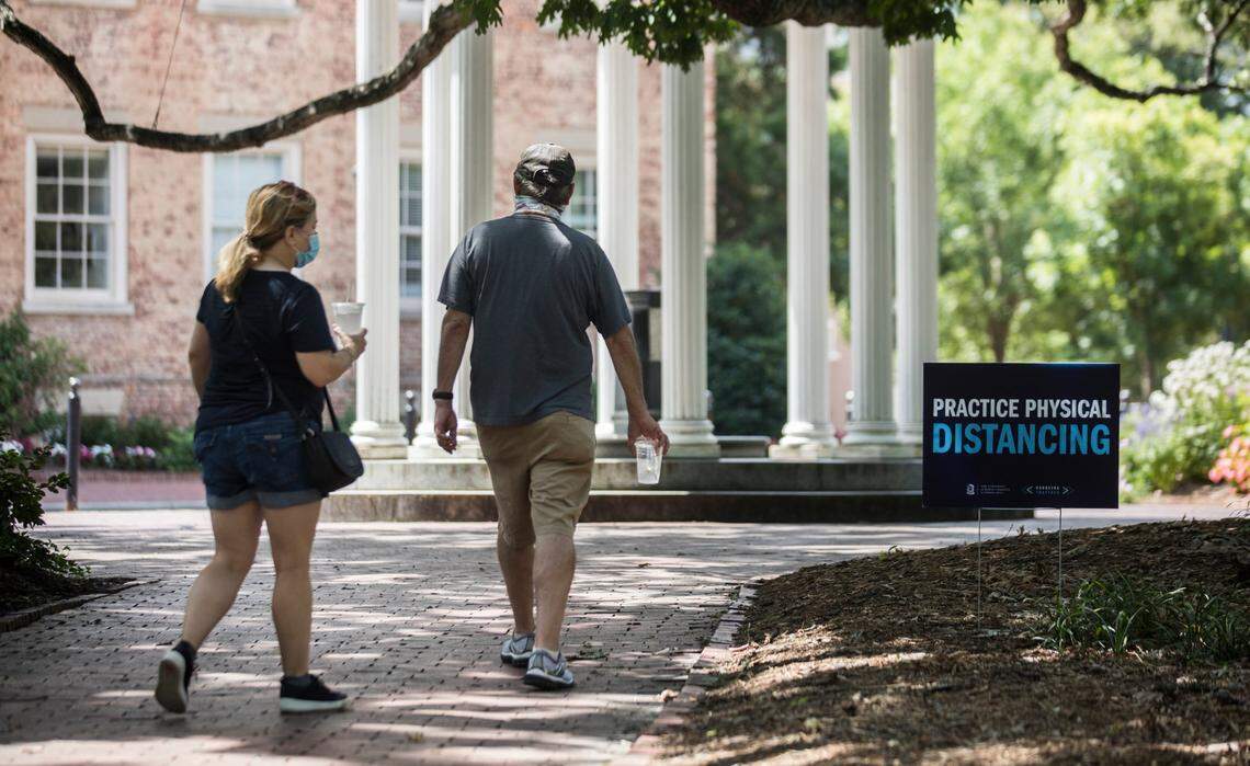 Signs about mask wearing and social distancing surround the Old Well on UNC-Chapel Hill’s campus, pictured here on Thursday, Aug. 6, 2020.