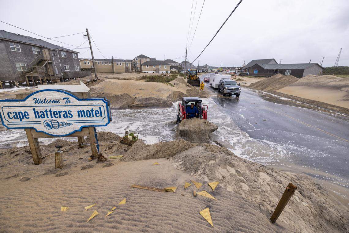 A compact track loader operator moves sand in an effort to prevent overwash on N.C. Highway 12 in Buxton on Saturday, Oct. 11, 2025, as a nor’easter is expected to impact the North Carolina coast.