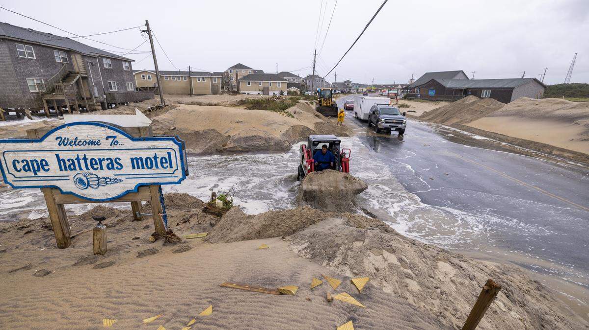 A compact track loader operator moves sand in an effort to prevent overwash on N.C. Highway 12 in Buxton on Saturday, Oct. 11, 2025, as a nor’easter is expected to impact the North Carolina coast.