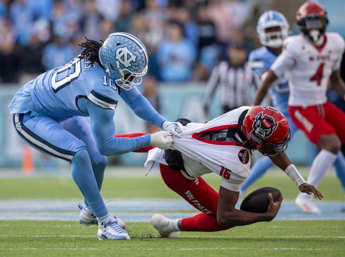 North Carolina defensive lineman Desmond Evans (10) sack N.C. State quarterback C.J. Bailey (16) in the first quarter on Saturday, November 30, 2024 at Kenan Stadium in Chapel Hill, N.C.