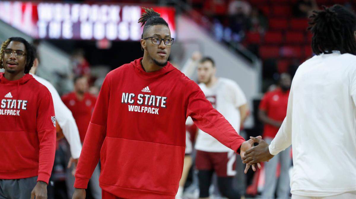 N.C. State’s Manny Bates (15) encourages Jaylon Gibson (11) before N.C. State’s game against Colgate at PNC Arena in Raleigh, N.C., Saturday, November 13, 2021.
