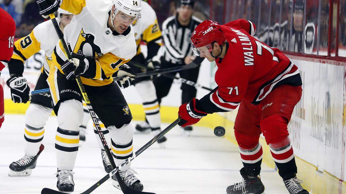 Pittsburgh Penguins’ Tanner Pearson (14) wins the battle with Lucas Wallmark (71) during the second period of an NHL hockey game, Saturday, Dec. 22, 2018, in Raleigh, N.C. (AP Photo/Karl B DeBlaker)