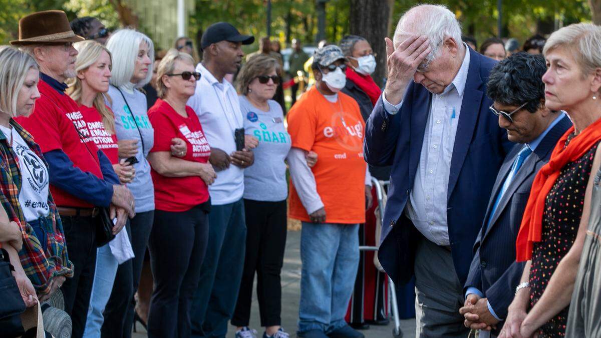 Rep. David Price, right, pays his respects to the victims of the mass shooting that killed five people on October 13, 2022 in the Hedingham neighborhood, during a vigil on Sunday, October 23, 2022 on Lichtin Plaza at Raleigh Memorial Auditorium in Raleigh, N.C.