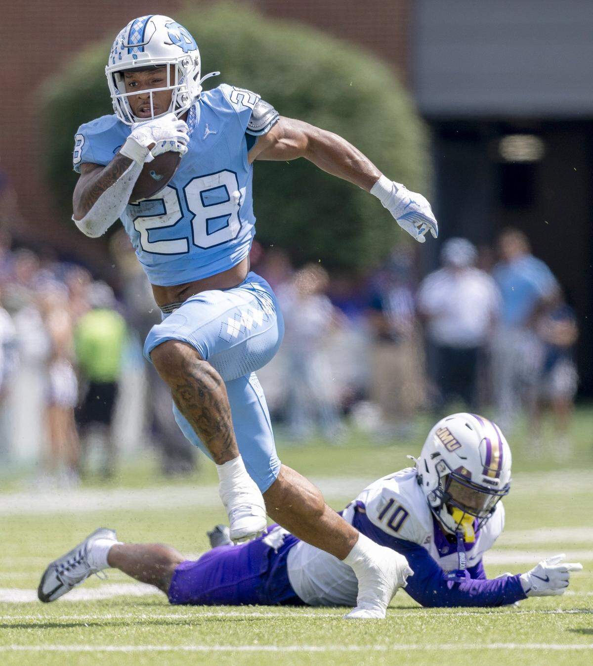 North Carolina running back Omarion Hampton (28) breaks away from James Madison defensive back Chris Shearin (10) for a 28-yard touchdown in the first quarter on Saturday, September 21, 2024 at Kenan Stadium in Chapel Hill, N.C.