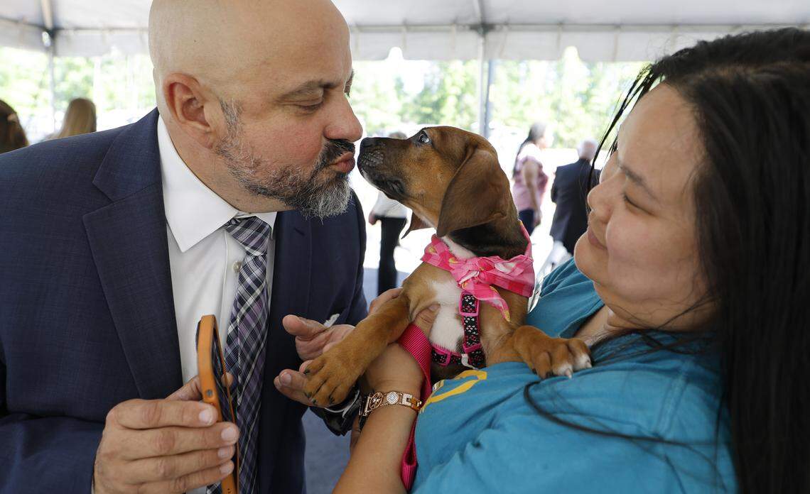 Bobby Matus gets a kiss from Maple before a ceremony to celebrate the completion of the SPCA of Wake County’s Peggy Garner Britt Resource Center in Raleigh, N.C., Thursday, April 23, 2026. Holding Maple is Mari Myers