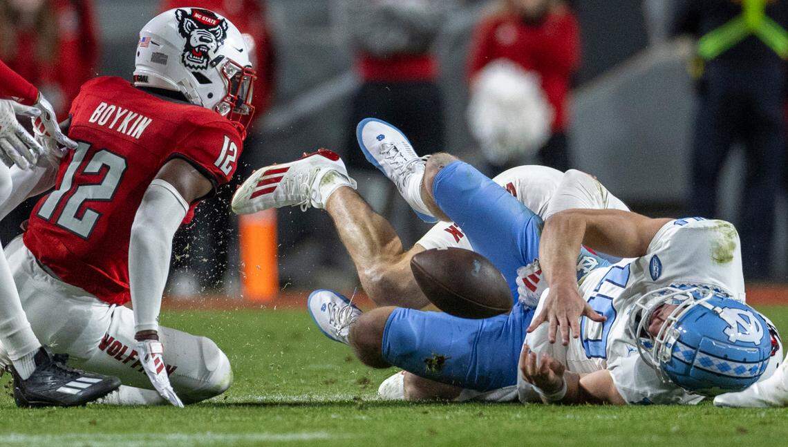 North Carolina quarterback Drake Maye (10) fumbles the ball in the first quarter after a hit by N.C. State linebacker Payton Wilson (11) on Saturday, November 25, 2023 at Carter-Finley Stadium in Raleigh, N.C.