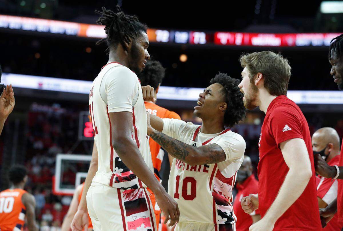 N.C. State’s Breon Pass (10) congratulates Jaylon Gibson (11) during the second half of Syracuse’s 89-82 victory over N.C. State at PNC Arena in Raleigh, N.C., Wednesday, Feb. 2, 2022.