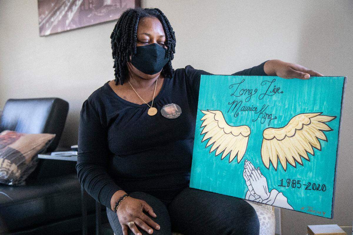 Tiffany King poses with a memorial painting for her son Maurice King, who died after a fight March 4, 2020, in the Orange County jail. State health department officials found that detention officers violated state regulations by never looking into his cell during inmate checks. Those regulations require jailers to check inmates at least twice an hour.