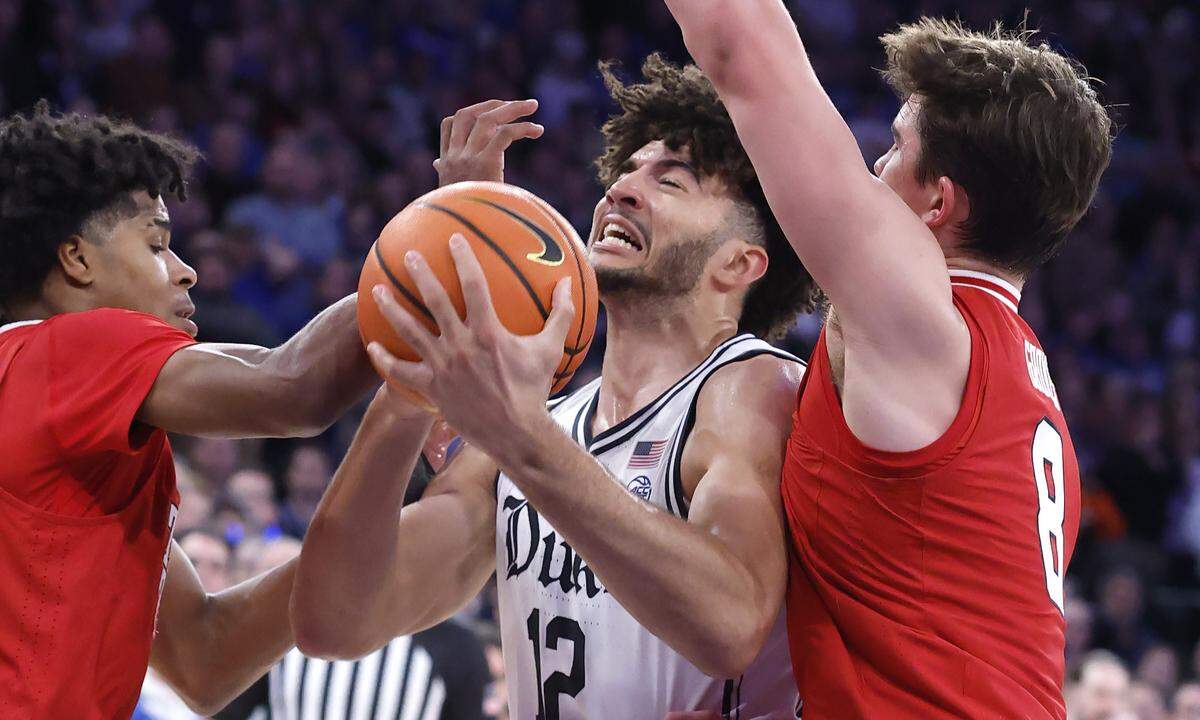 Texas Tech's Christian Anderson (4) and Nolan Groves (8) defend Duke’s Cameron Boozer (12) during the second half of Texas Tech’s 82-81 victory over Duke in the SentinelOne Classic at Madison Square Garden in New York City on Saturday, Dec. 20, 2025.