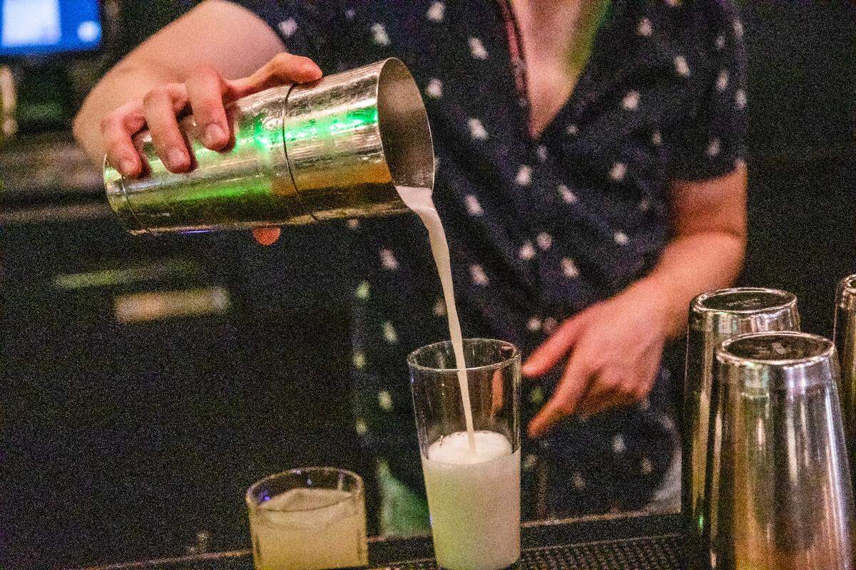 Bartender Clovis LaCour mixes a drink at Dram & Draught in Raleigh Friday night, Oct. 2, 2020. The state moved into Phase 3 of its reopening plan Friday at 5 p.m., meaning private bars could open at 30 percent of their outdoor capacity.