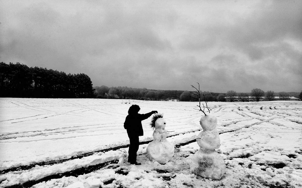 N.C. State University student Fahad Alsuwaidi, 21, works on two snowmen in the middle of a large field on Dix Hill in Raleigh, NC Thursday afternoon, Feb. 13, 2014. Alsuwaidi, who is from the United Arab Emirates, was experiencing his first snow.