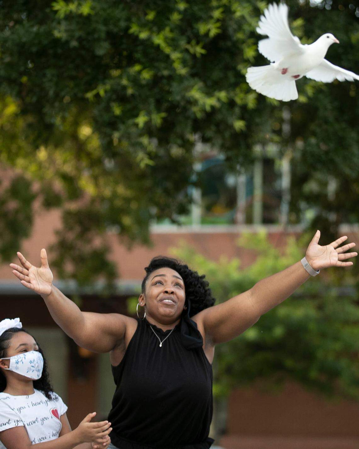 Shannon Utley releases a white dove in honor of Kyron Hinton, one of several families with loved ones who died or faced excessive force at the hands of Raleigh police during a vigil in Moore Square on Tuesday, June 9, 2020 in Raleigh, N.C. Kyron Hinton’s daughter, nine-year-old Kyra Utley stands with her mother.