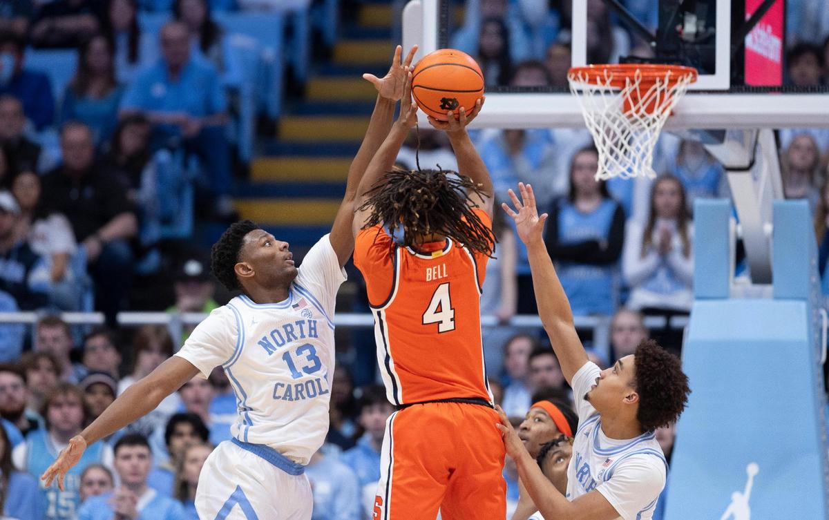 North Carolina’s Jalen Washington (13) and Seth Trimble (7) defends Syracuse’s Chris Bell (4) in the first half on Saturday, January 13, 204 at the Smith Center in Chapel Hill, N.C.