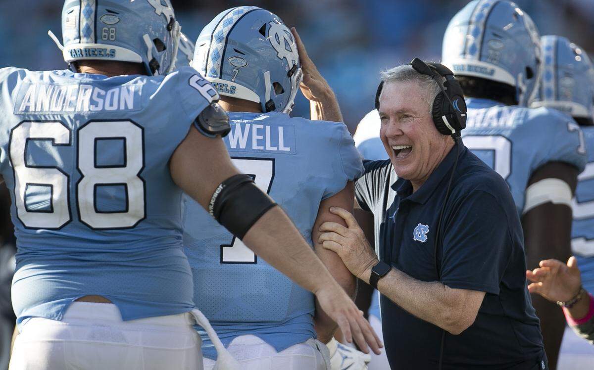 North Carolina coach Mack Brown greets quarterback Sam Howell (7) after he completed a touchdown pass to Dyami Brown in the fourth quarter against South Carolina on Saturday, August 31, 2019 at Bank of America Stadium in Charlotte, N.C. Howell completed 15 of 24 passes for 245 yards and two touchdowns.