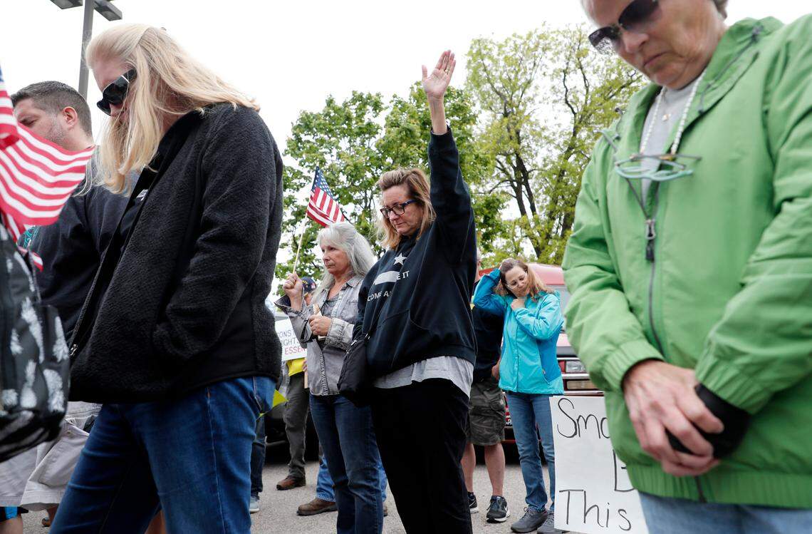 Demonstrators pray while gathering in downtown Raleigh, N.C., during a ReOpenNC protest Tuesday, May 5, 2020.