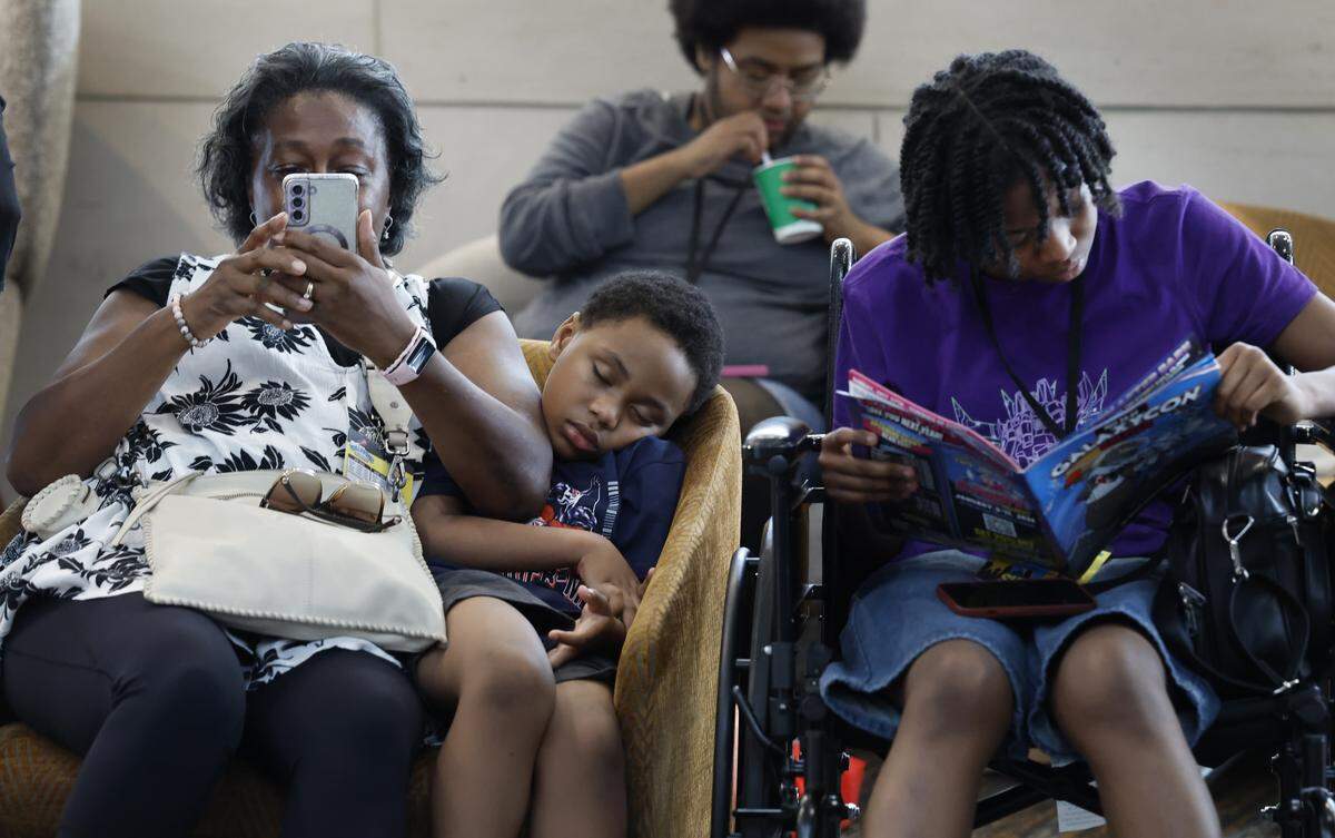 Miles Burgess, 7, sleeps as he sits with his grandmother Ethel Bowser and sister Mazhonee Burgess, 15, late in the day during GalaxyCon Raleigh at the Raleigh Convention Center Sunday, July 27, 2025. The family traveled from Denwiddie, Va., leaving home at 7 am.