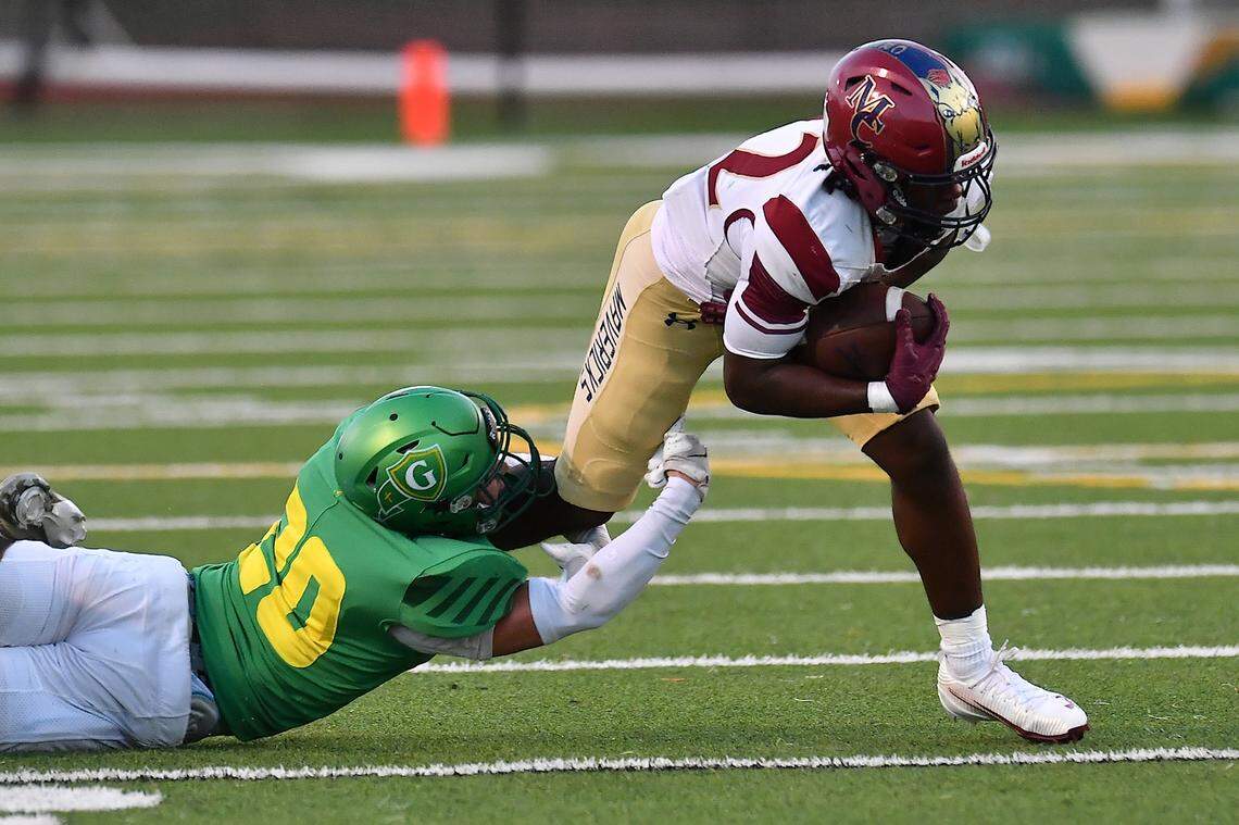Cardinal Gibbons defensive back Jack Richards (20) grapples Mallard Creek's Joshua Pearson (22) during the first half. The Mallard Creek Mavericks and the Cardinal Gibbons Crusaders met in a non-conference football game in Raleigh, N.C. September 19, 2025