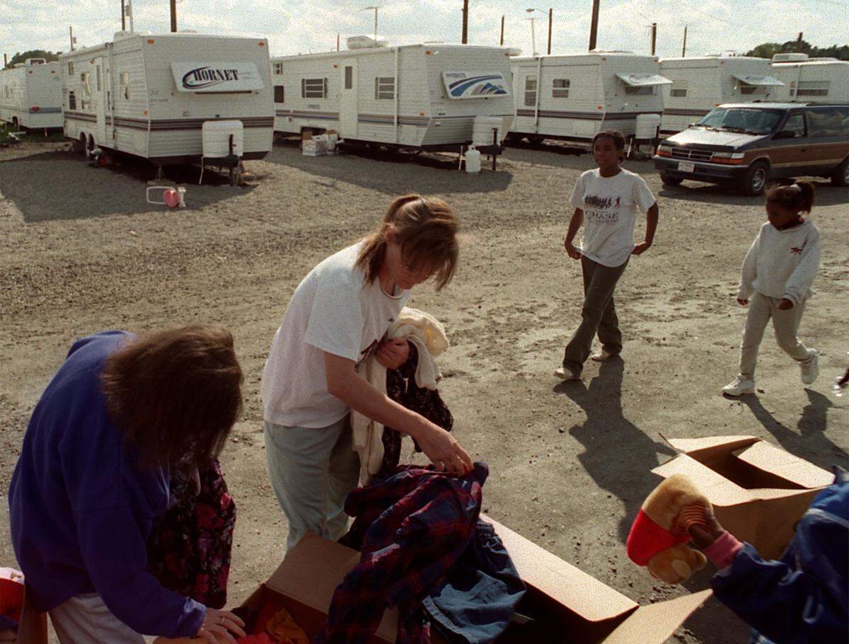 Joyce Forrest (left) and her daughter Sandy Kaler (center) barely made it out of their mobile home in Battleboro as floodwaters rose after Hurricane Floyd. TIn this file photo, the two  fishe through donated clothing at a refugee trailer park in Rocky Mount, where they were temporarily living. 