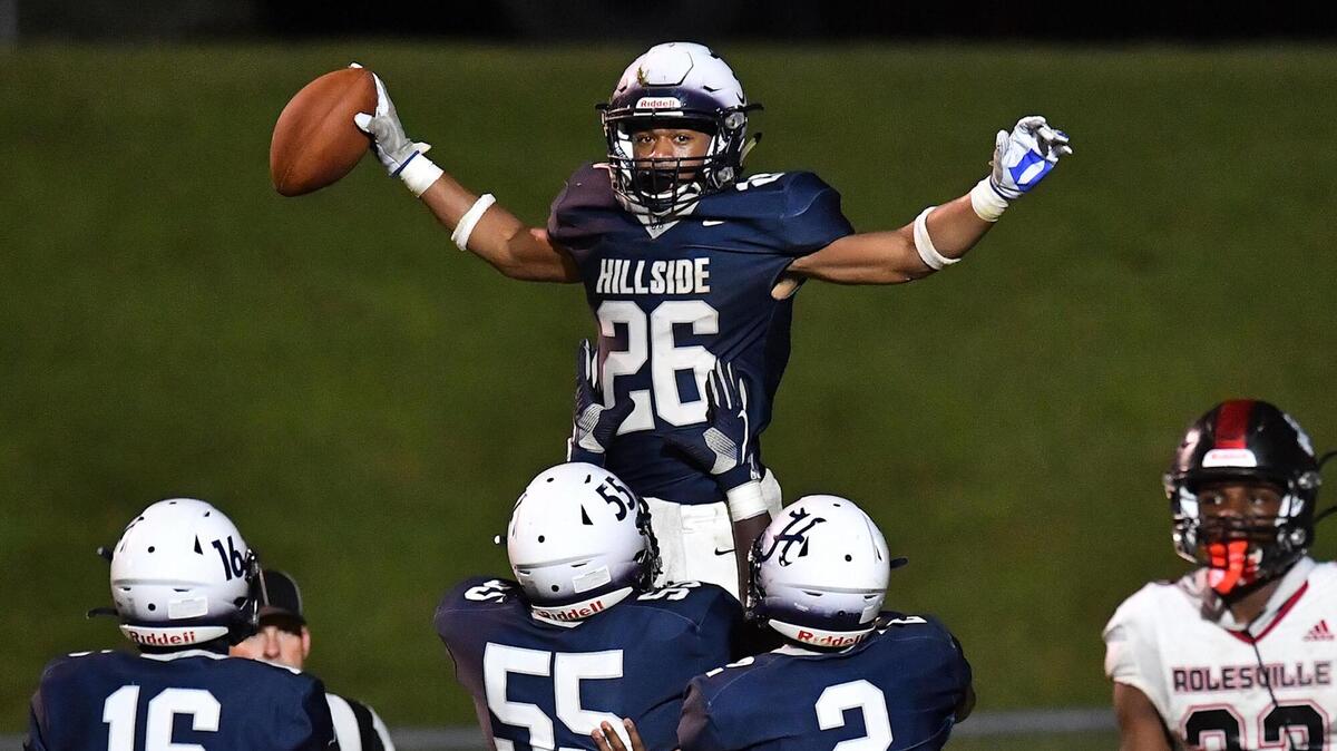 illside’s Rayshone Allen (55) hoists up and celebrates with Jimmyll WIlliams (26) after his touchdown against Rolesville in the third quarter. The Durham Hillside Hornets and the Rolesville Rams met in a football game in Durham, N.C. on September 9, 2022.